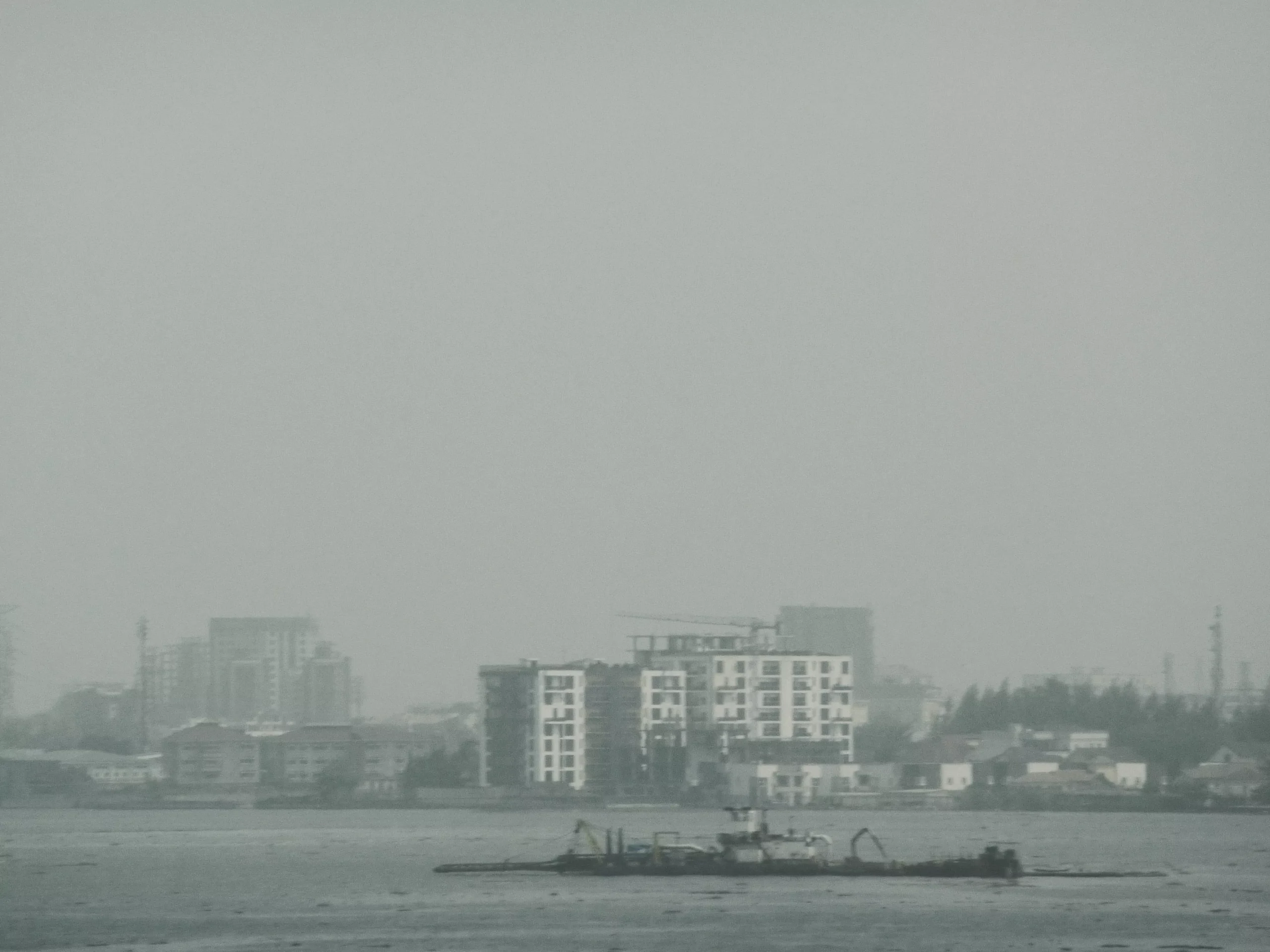 black and white photo of boat on atlantic ocean overlooking the city 